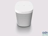 a white speaker sitting on top of a table next to a wall