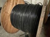 a spool of black wire on a wooden stand