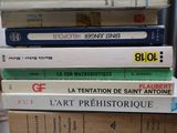 many books stacked on top of each other on a table
