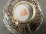 a small silver cup with a handle on a table