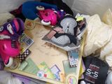a pile of stuffed animals and other items on a bed