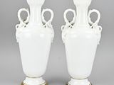 pair of white vases with gold trim and handles