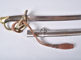 a close up of a sword on a white surface