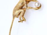 an image of a monkey brooch with a pearl in its mouth