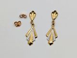 a pair of gold and silver earrings on a white surface