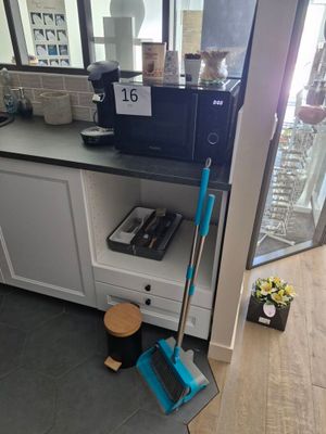 un balai et une serpillière posés par terre dans une cuisine