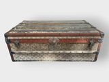 an old trunk sitting on top of a white surface