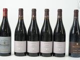 six bouteilles de vin sont alignées sur une table