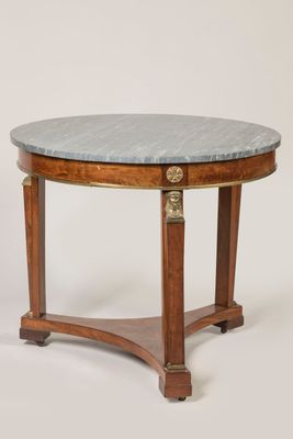 a round table with a marble top and wooden legs