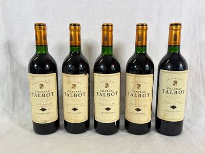 quatre bouteilles de vin rouge sont alignées sur une table