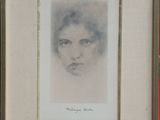 painting of a woman ' s face in a frame on a table