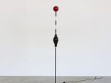un lampadaire noir et rouge surmonté d'une boule rouge