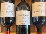 three bottles of wine sitting in a wooden box