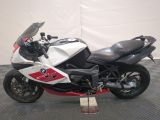 motorcycle parked on a black and white checkered floor in front of a white wall