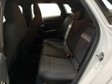 the back seats of a white car with a black seat belt
