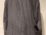 grey jacket on a mannequin hanger on a white wall