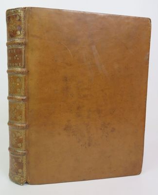 an old book with a brown cover sitting on top of a white surface
