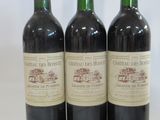 three bottles of red wine sitting on top of a white table