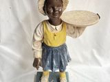 figurine représentant une petite fille avec un chapeau et un panier sur la tête