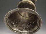 a silver vase that is sitting on a table