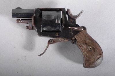 un petit pistolet posé sur une surface blanche