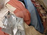 a pile of clothes sitting on a bed in a room