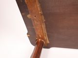 a piece of luggage sitting on a table with a wooden handle