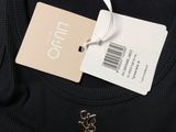 the back of a black t - shirt with a tag on it