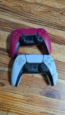 deux manettes de jeux vidéo posées sur un parquet