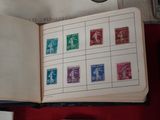 un livre ouvert avec des timbres, posé sur une table