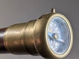 a close up of a brass telescope with a compass on it