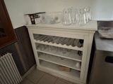 a wine rack with glasses on it in a kitchen