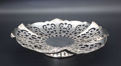 a close up of a silver plate on a black surface