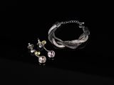 a close up of a bracelet and earring on a black surface
