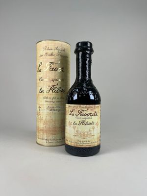 une vieille bouteille de vin posée à côté d'un carton