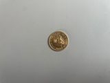 gros plan d'une pièce d'or sur une surface blanche