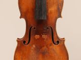 an old violin with a bow hanging from it ' s back