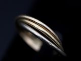 a close up of a gold and silver ring on a black surface