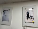 two pictures hanging on the wall of a bike shop