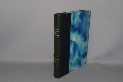 an old book sitting on top of a white table next to a white wall