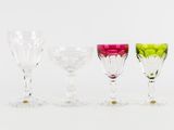 quatre verres à vin de couleurs différentes sont alignés sur une surface blanche