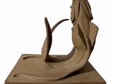 statue of a mermaid with a long tail sitting on a block