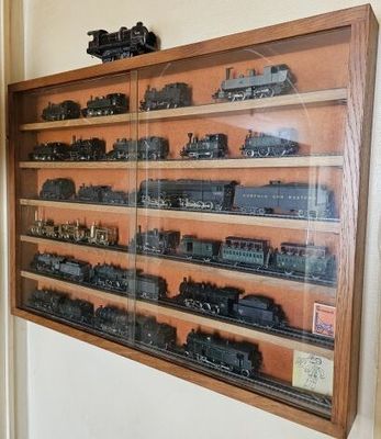 de nombreux trains miniatures exposés dans une vitrine