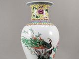 un vase avec un oiseau posé sur une table