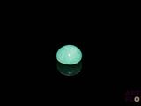 un gros plan d'une boule verte lumineuse posée sur une surface noire