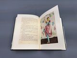 un livre ouvert sur lequel figure l'image d'une femme en robe rose