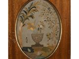 tableau représentant un vase orné de fleurs et de feuilles, dans un cadre en bois