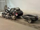 a motorcycle and a car on a trailer in a garage