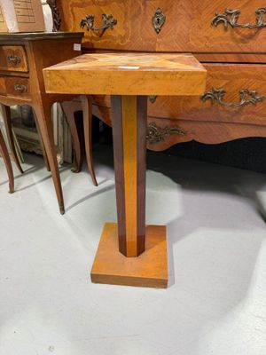 une petite table en bois posée directement sur le sol, avec un piètement en bois