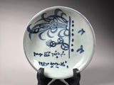a blue and white plate sitting on a wooden stand